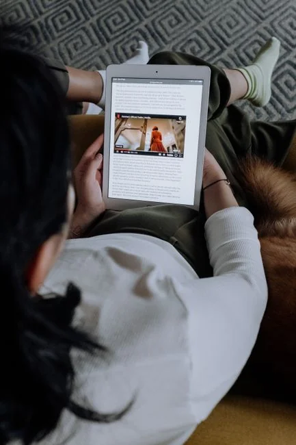 A modern workspace showing hands analyzing marketing data on a laptop and paper documents.